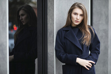 Beautiful girl in a coat in business downtown