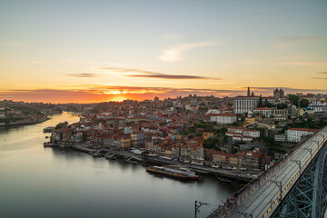 The cityscape of Porto with a bridge in the foreground at sunset and nightfall
