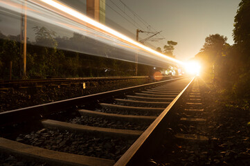 Light trail of the express train in the railway station at the night. High speed passenger train on...