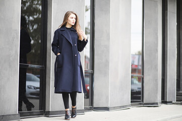 Obraz premium Beautiful girl in a coat in business downtown