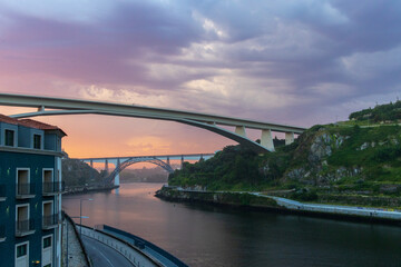 Fototapeta premium Morning light creates colorful pink clouds over a river in Porto, Portugal