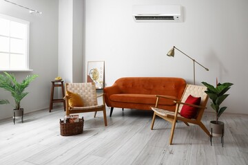 Interior of modern living room with sofa, armchairs and air conditioner