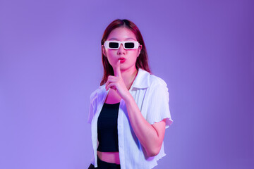 asian woman in black tank top and white shirt wearing sunglasses posing ove isolated purple background.