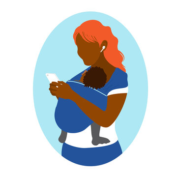 An African American woman uses a smartphone while holding a baby in a kangaroo bag. Wearing in a sling. Mother's free hands. Newborn laid back nursing care. 