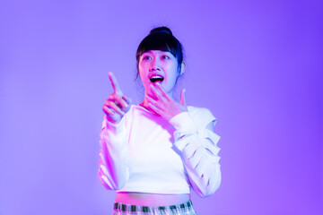 Young asian woman in white fashion sweatshirt posing exciting on the purple background.
