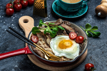 Keto diet breakfast or lunch dish Baked sweet purple potatoes, grilled bacon and fried egg in pan and coffee. Healthy fats, clean eating for weight loss, top view