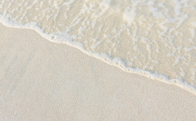 Close-up of white sand, washed by soft sea waves