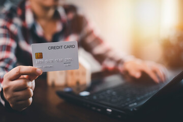 Woman holding credit card for makes a purchase on the Internet on the laptop computer with credit card, online payment, shopping online, e-commerce, internet banking, spending money concept.