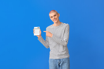 Young guy pointing at calculator on blue background