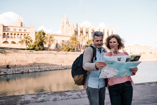 Mature couple reading map in city on vacation