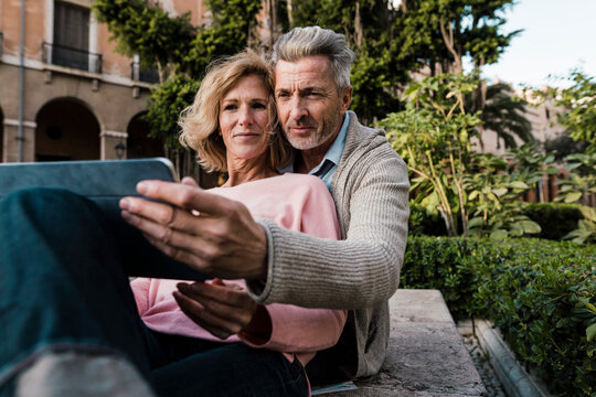 Mature couple using tablet computer in park
