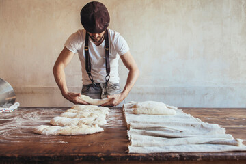 Baker arranging dough on napkin for proofing in bakery