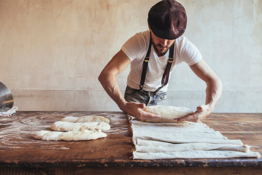 Baker arranging dough on napkin in bakery