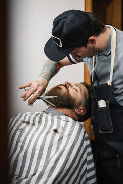 Barber Trimming Up Clients Beard In Salon