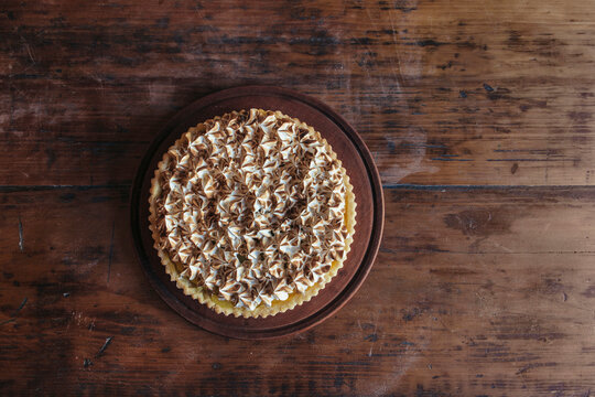 Fresh meringue cake on wooden table in bakery