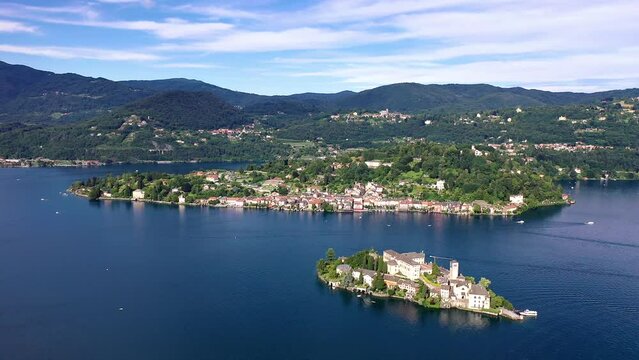 Flug &uuml;ber den Ortasee (Lago Orta) mit Blick &uuml;ber den See zur Insel San Giulio mit der mittelalterlichen historischen Basilika, Abtei und Kloster, Sommer, Sonne, blauer Himmel, Novara, Piemont, Italien