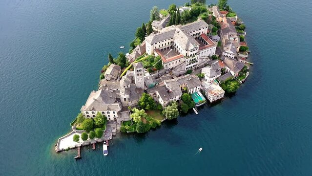 Flug &uuml;ber den Ortasee (Lago Orta) mit Blick &uuml;ber den See zur Insel San Giulio mit der mittelalterlichen historischen Basilika, Abtei und Kloster, Sommer, Sonne, blauer Himmel, Novara, Piemont, Italien