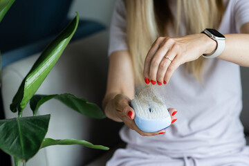 Portrait of stressed young blonde balding woman looking at unhealthy hair on brush, checking...