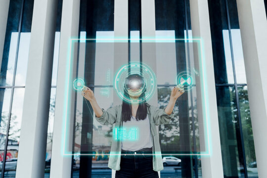 Woman wearing VR glasses touching virtual screen in front of column