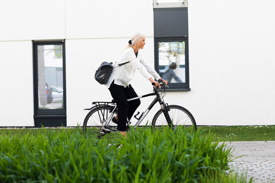 Mature businesswoman commuting to work on bicycle