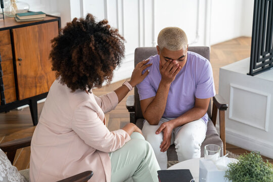 Sad patient with psychologist consoling at workplace