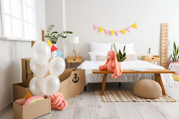 Interior of bedroom with toy cardboard ship and balloons