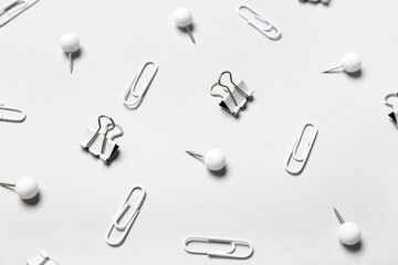Different paper clips and pins on light background