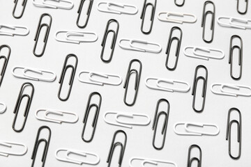 Black and white paper clips on light background