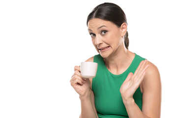 A young worried woman gossips with a cup of coffee in her hand on a white background