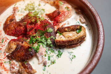 closeup of georgian chkmeruli chiken meat with cream sauce and cilantro in bowl 