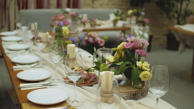 Beautiful wedding decor, all decorated in pink pastel colors, camera moving slow motion. Festive served plates on the table.