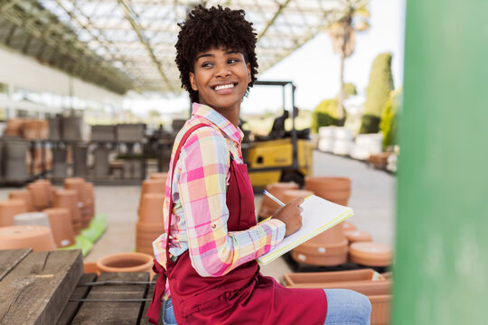 Happy gardener looking away preparing inventory in warehouse