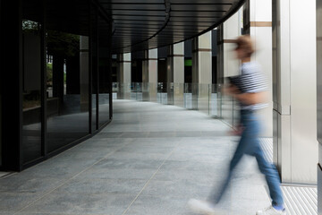 Blurred motion of woman entering in building