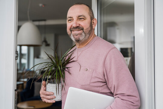 Businessman with dragon tree and laptop in new office