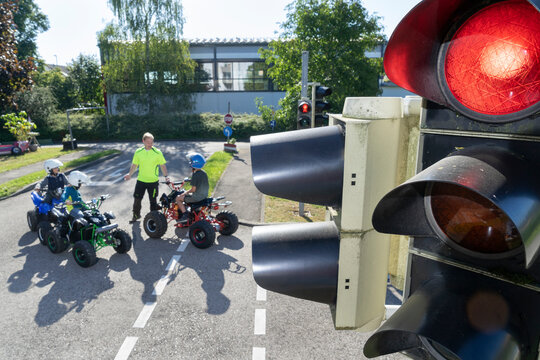 Instructor giving training to children on quadbikes at traffic education training