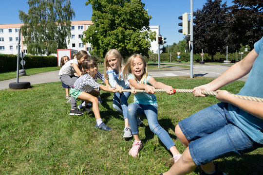 Children playing tug-of-war on sunny day