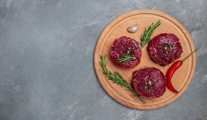 Beef medallions with rosemary and spices, Raw beef meat steak Tenderloin fillet on a dark background. banner, menu, recipe place for text, top view