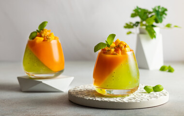Summer dessert with exotic fruits. Mango, papaya, passion fruit and kiwi jelly dessert in glass. - obrazy, fototapety, plakaty