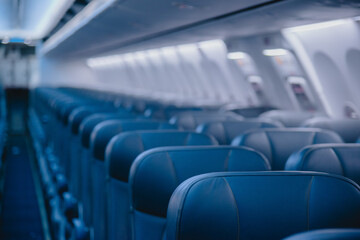 Fototapeta premium View of blurred empty passenger airplane seats in the cabin in blue colored, blurred of empty seat in the aircraft