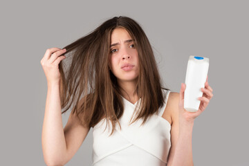 Woman hand holding bootle shampoo with serious hair loss problem for health care shampoo.