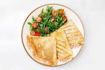 Pancake with bacon and salad on a white background