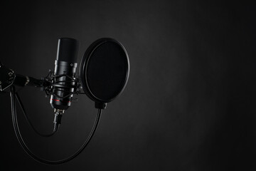 Close up image of professional studio microphone on the black background during voice recording
