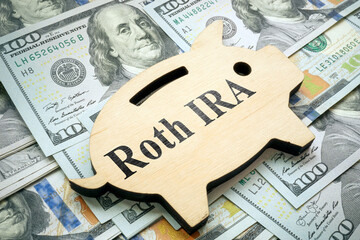 Piggy bank with sign Roth IRA on money.