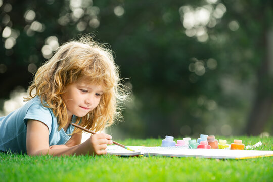 Child boy painting art in park outdoor.