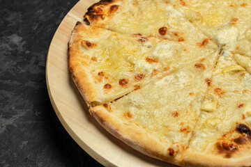 Italian food Delicious pizza Four Cheeses with cheddar, Parmesan, mozzarella on a dark background, Food recipe background. Close up