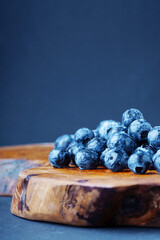 Blueberry on a picturesque wooden board. Vertical composition.
