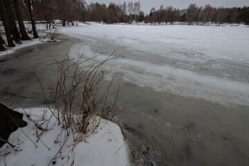 Spring landscape with a river. Snow melts in March. Evening in early spring.