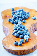 A handful of blueberries on a wooden board. Vertical photography.