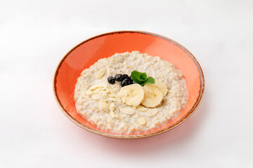 Porridge with milk and bananas on a white background.