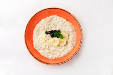 Porridge with milk and bananas on a white background.